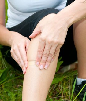 sportsman showing swollen Knee tendonitis pain having treatment in cardiff for sports injuries