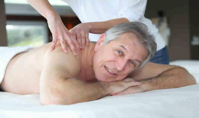 disabled elderly man having massage for Crohn's at our Cardiff clinic