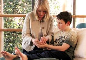 young boy with ADD learning hand reflexology in Cardiff autism centre - to aid sleep and digestion